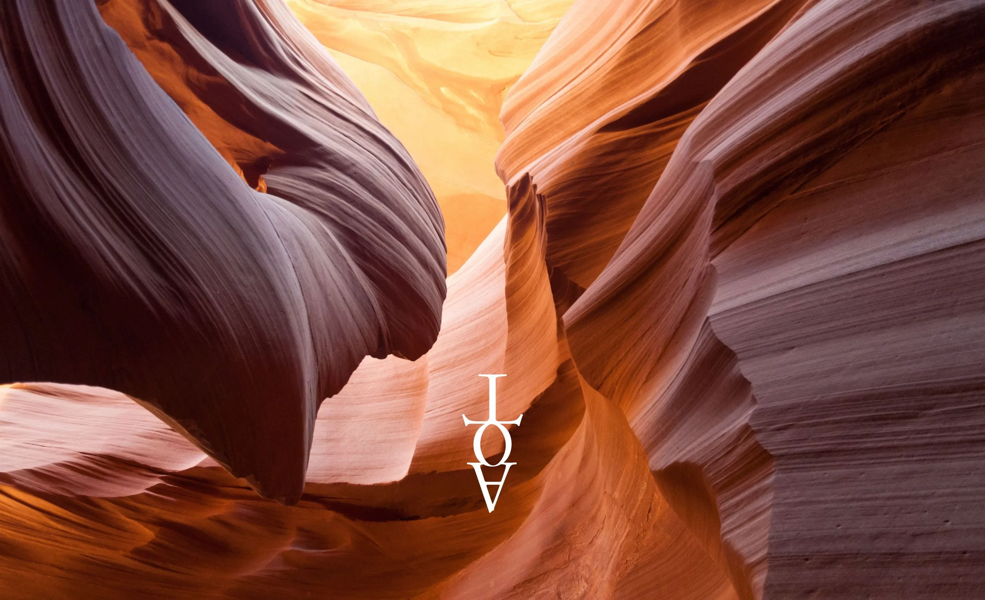 The Arrow of Time logo hovering above majestic and warmly coloured wind swept stone at Antelope Canyon, Arizona